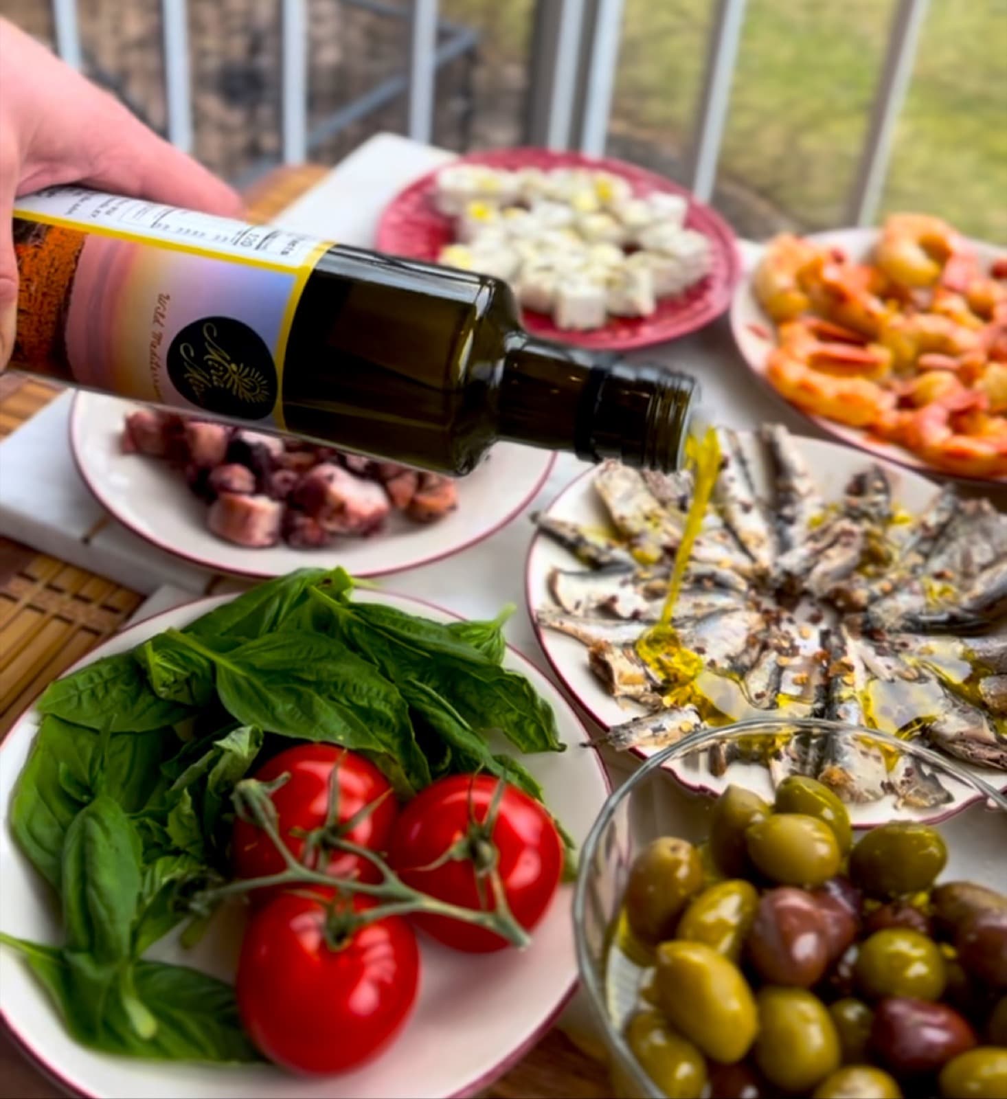 Bread, olives, tomatoes and Mediterranean table foods for tasting Vuno olive oil